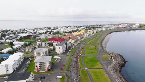Marathon-runners-on-road-in-urban-landscape-of-Reykjavik,-aerial