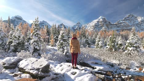 Woman-standing-in-snowy-landscape-looking-at-Valley-of-the-Ten-Peaks