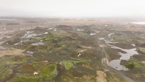 Aerial-panoramic-view-of-Raudholar-craters,-the-Red-Hills,-geological-formations-of-volcanic-rocks,-in-Iceland-on-a-cloudy-day