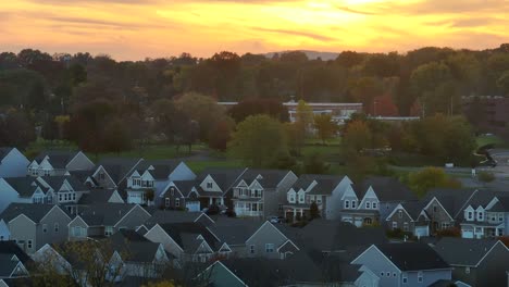 Row-of-suburban-homes-with-gable-roofs-against-a-sunset-sky