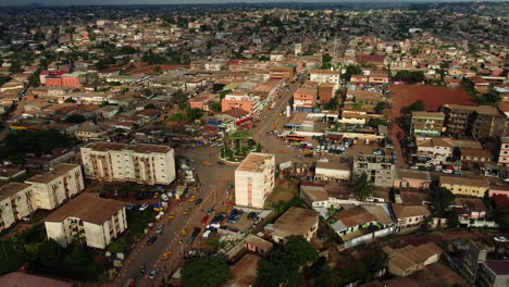 Aerial-view-overlooking-traffic-at-a-roundabout-in-the-suburbs-of-Yaounde,-sunny-Cameroon