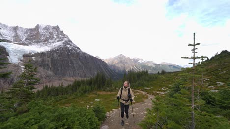Mujer-Caminando-Con-Bastones-De-Marcha-Nórdica-En-El-Verde-Valle-Alpino-A-Través-De-Las-Montañas-Rocosas-Canadienses