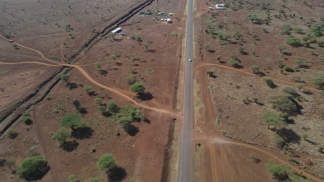 Modern-infrastructure-in-Kenya,-asphalt-highway-passing-arid-rural-landscape