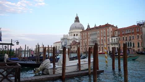 Dock-with-boat-and-gondolas-at-Venice-Grand-Canal-with-views-of-Basilica-Santa-Maria-della-Salute