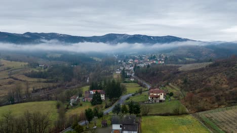 Mist-cloud-over-countryside-landscape-with-road-in-village,-timelapse