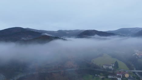 Bewölkter,-Düsterer-Himmel-Und-Nebelwolke-über-Hügeliger-Landschaft