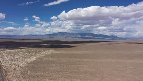 Langsam-Ziehende-Wolken-Und-Schatten-Treiben-über-Die-Wüste-Von-Nevada-Mit-Blauem-Himmel-Und-Bergen-In-Der-Ferne