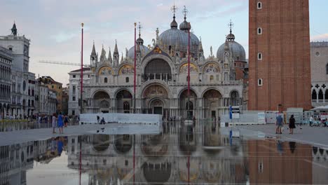 Basilica-di-San-Macro-and-reflection-during-sunset-with-many-tourists