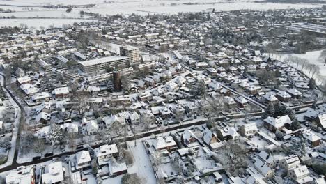 Beautiful-aerial-of-a-small-town-with-a-municipal-water-tower-in-the-center-on-a-sunny-winter-day