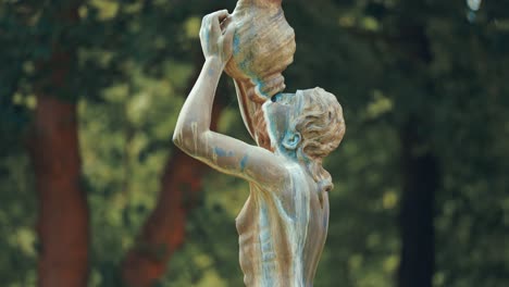 Eine-Statue-Einer-Frau,-Die-Aus-Der-Amphore-Trinkt,-Auf-Dem-Verschwommenen-Hintergrund