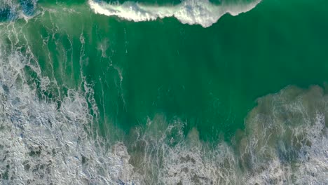 Luftaufnahme-Von-Schaumigen-Wellen,-Die-In-Zeitlupe-Am-Strand-Rollen