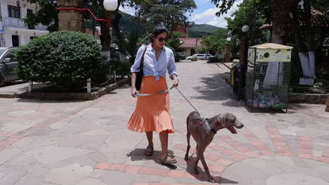 Hispanic-woman-walks-her-dog-on-charming-Samaipata-street-in-Bolivia