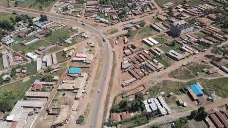 Traffic-on-highway-passing-Loitokitok-town,-Kenya,-aerial-view