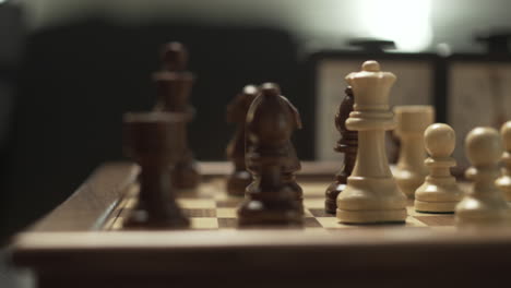 Detail-of-movement-of-the-white-queen-piece-over-dark-pieces-in-a-professional-chess-game