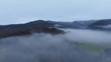 Nebelwolke-Schwebt-über-Der-Hügeligen-Landschaft-Unter-Bewölktem-Himmel