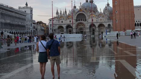 Woman-rests-head-on-her-boyfriend-shoulder-while-admiring-Basilica-di-San-Marco,-Venice