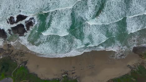 Top-Down-View-Over-Ocean-Waves-With-Foam-Splashing-On-The-Seashore---Drone-Shot