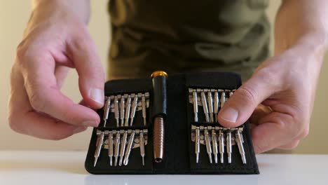 Man-preparing-precision-screwdriver-set,-close-up
