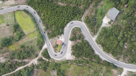Aerial-view-of-multiple-cars-in-line-drive-on-Albanian-mountain-serpentine-road