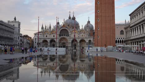 Flooded-Piazza-San-Marco-reflecting-Basilica-and-Campanile-at-sunset-in-Venice,-Italy