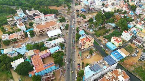 Tiruchirappalli-intersection-with-moving-vehicles-and-surrounding-buildings,-aerial-view