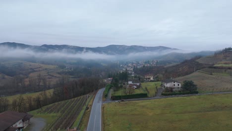 Nebelwolke-über-Dorflandschaft-Mit-Straße-Unter-Bewölktem-Himmel