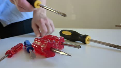 Woman-choosing-and-grabbing-screwdriver-of-multiple-screwdrivers,-close-up