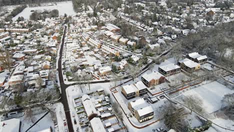 Drone-flying-backwards-over-a-beautiful-snow-covered-town-with-clean-streets