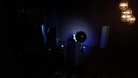 Interview-recording-in-dark-indoor-podcast-studio-environment,-blue-hue-light
