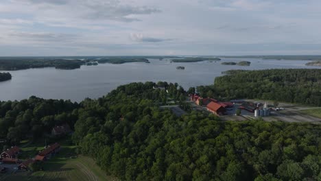 Aerial---Forward-panning-drone-shot-of-Taxinge-Castle-by-forest-and-lake