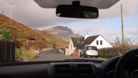 driving-past-quaint-cottage-on-the-road-towards-old-man-of-storr-on-Isle-of-Skye,-hIghlands-of-Scotland