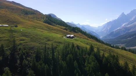 Drone-shot-spinning-around-a-mountain-cabin-in-the-italian-alps-to-reveal-the-mountainscape