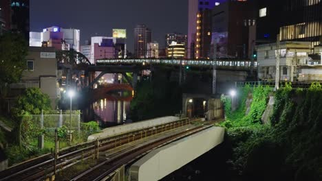 Long-JR-Train-arrives-at-Station-in-Akihabara-District-of-Tokyo-at-Night-4k
