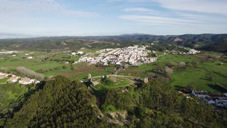 Viewpoint-from-castle-to-city-Aljezur-and-countryside-of-Portugal,-aerial-orbit