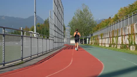 Rear-Of-A-Sporty-Man-Running-On-Stadium-Track