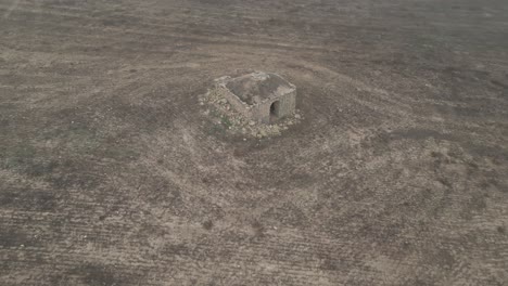 Old-hermitage-of-Sant-Esteban-in-ruins-in-middle-of-arid-field,-aerial-view