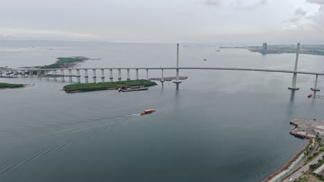Aerial-of-boat-heading-under-the-Cub-Cordova-Link-Expressway-in-Cebu---Philippines