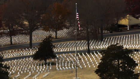 Fayetteville-National-Cemetery,-aerial-flying-around-American-flag-on-pole