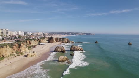 Cinematic-aerial-forward-at-beach-Portimao-Praia-dos-Tres-Castelos,-stone-beach