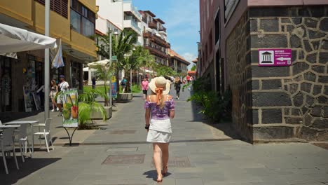 Atractiva-Mujer-Caminando-En-La-Exótica-Ciudad-De-Puerto-De-La-Cruz,-Tenerife,-Vista-Trasera
