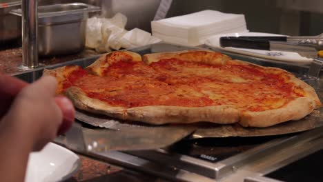 Close-up-shot-of-taking-a-piece-of-freshly-baked-pizza,-Italian-Pizza-on-MSC-Cruise