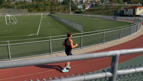 Male-Athlete-Running-On-Athletic-Track---Tracking-Shot