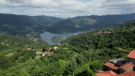 Luftaufnahme-Von-Häusern-Im-Nationalpark-Gerês,-Portugal,-Mit-Blick-Auf-Den-Caniçada-Staudamm-An-Einem-Klaren-Tag,-Nationalpark-Peneda-Gerês