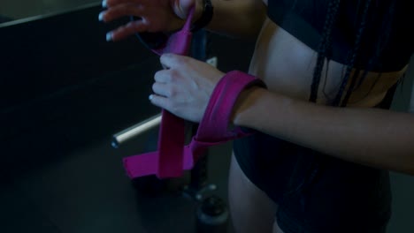 A-fit-girl-putting-on-her-weight-straps-to-prepare-for-an-intense-work-out-at-the-gym