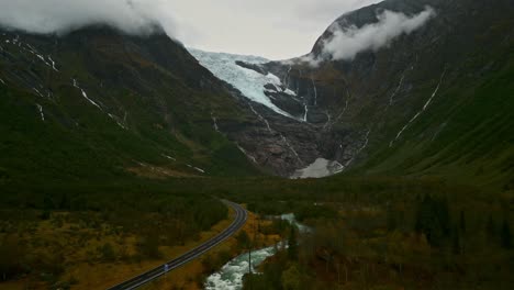 Drohne-Fliegt-Durch-Ein-Tal-über-Einer-Norwegischen-Straße-Auf-Einen-Wolkenverhangenen-Gletscher-Zu