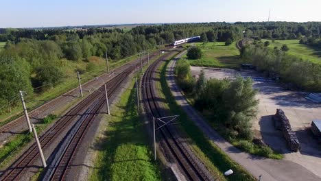Aerial-view-of-a-high-speed-train-moving-through-the-countryside-on-a-sunny-day