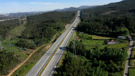 Peaceful-highway-by-farmland-fields-with-electricity-pylons-cutting-across-forest-in-Gondomar-Portugal