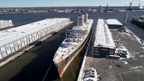 SS-Vereinigte-Staaten-Drohne-Schnee-Winter-Hoch-Bis-Tief-Eines-Verlassenen-Historischen-Schiffes,-Das-In-Philadelphia-Angedockt-Ist