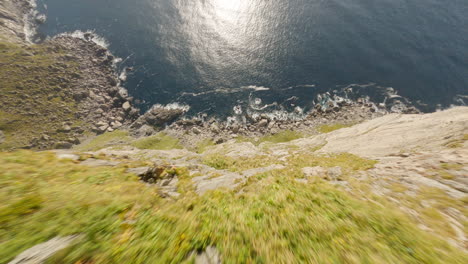 Impressive-Dive-of-a-Mountain-Cliff-overhanging-the-sea-on-the-Ryten-hike-in-Lofoten-Island,-Norway,-FPV-drone-flight