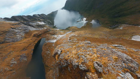 Tauchen-Auf-Einem-Bergkamm-Von-Reinebringen-Mit-Wunderschönen-Seen-Im-Hintergrund,-Filmischer-FPV-Drohne,-Lofoten-Inseln-In-Norwegen